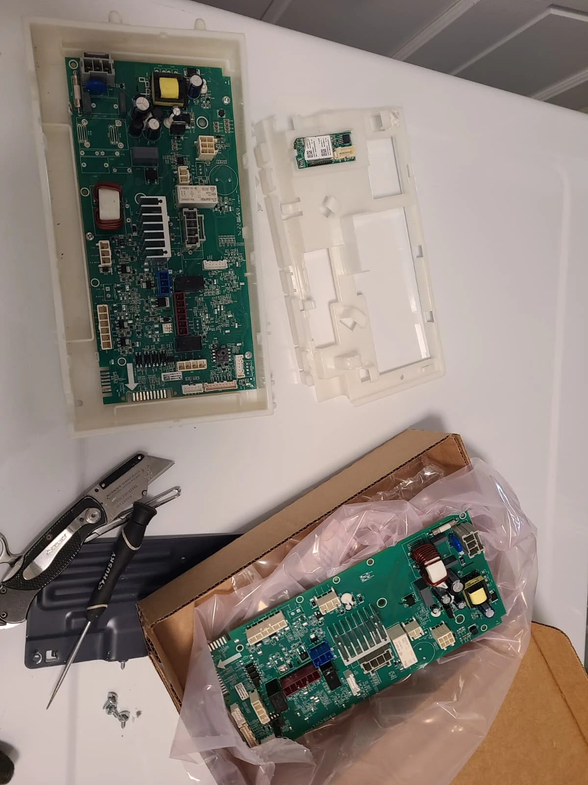 Removed control board in its housing beside the replacement board