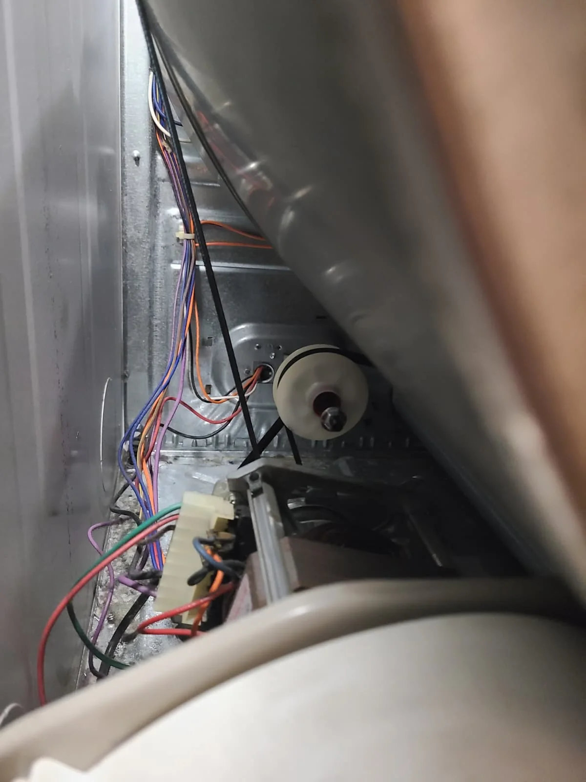 Installed belt visible beside the drum and idler pulley during reassembly