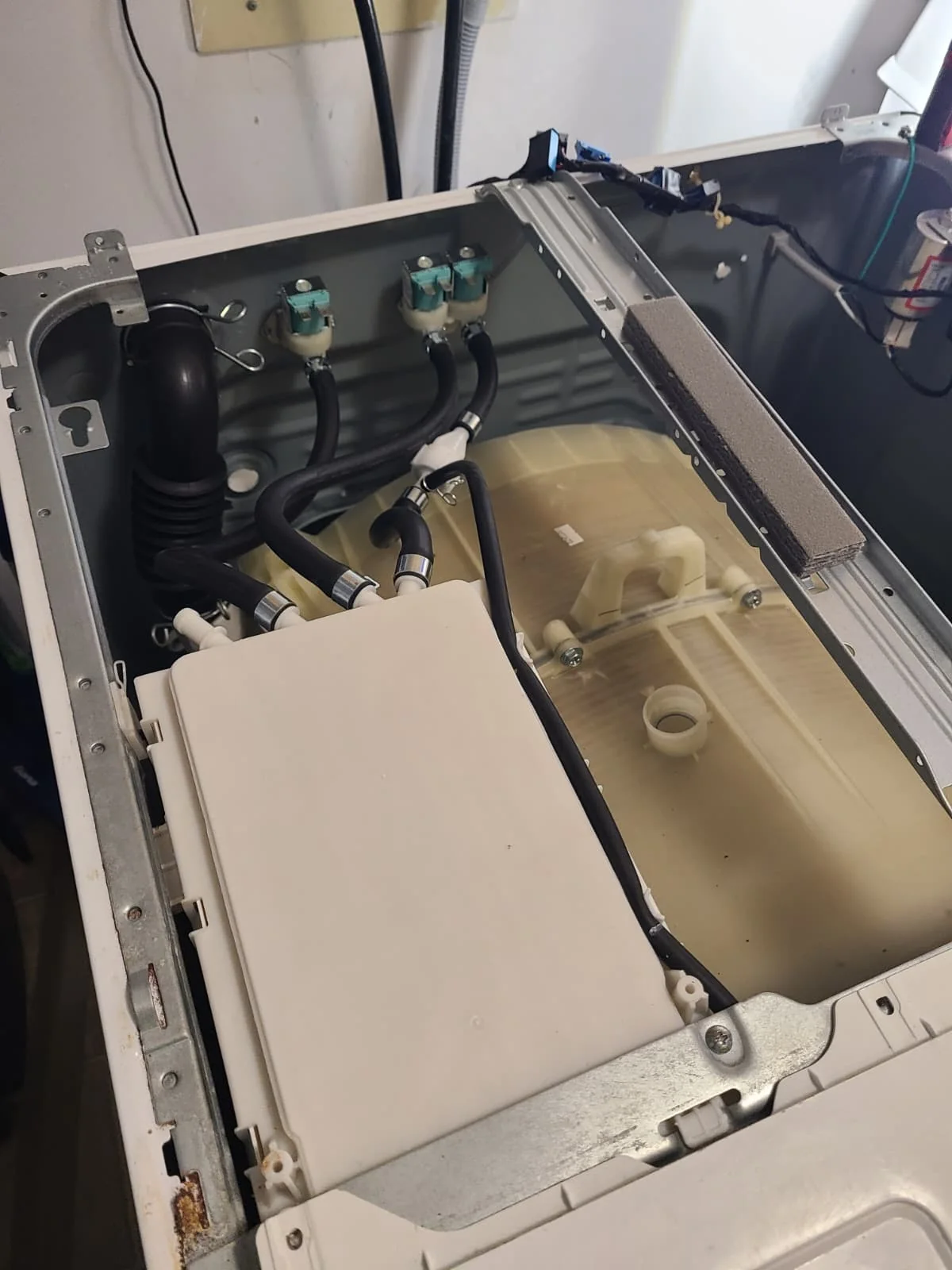 Replacement housing and hose routing inside the open washer during reassembly