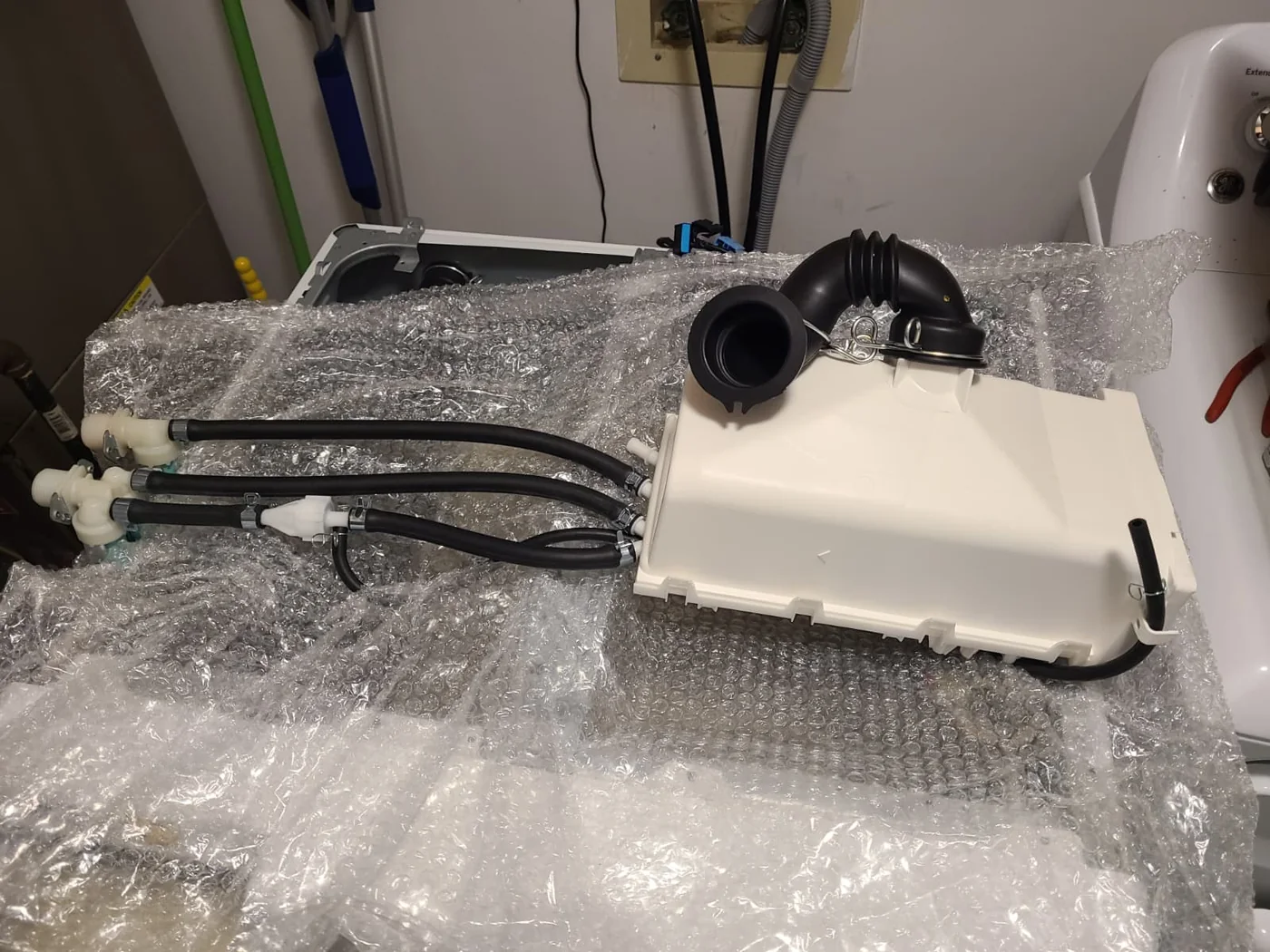 Replacement Samsung DC97-07125Z drawer housing assembly with hoses and valves laid out before installation