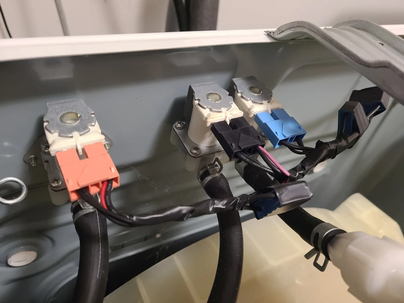 Water inlet valves, electrical connectors and dispenser hoses inside the Kenmore washer