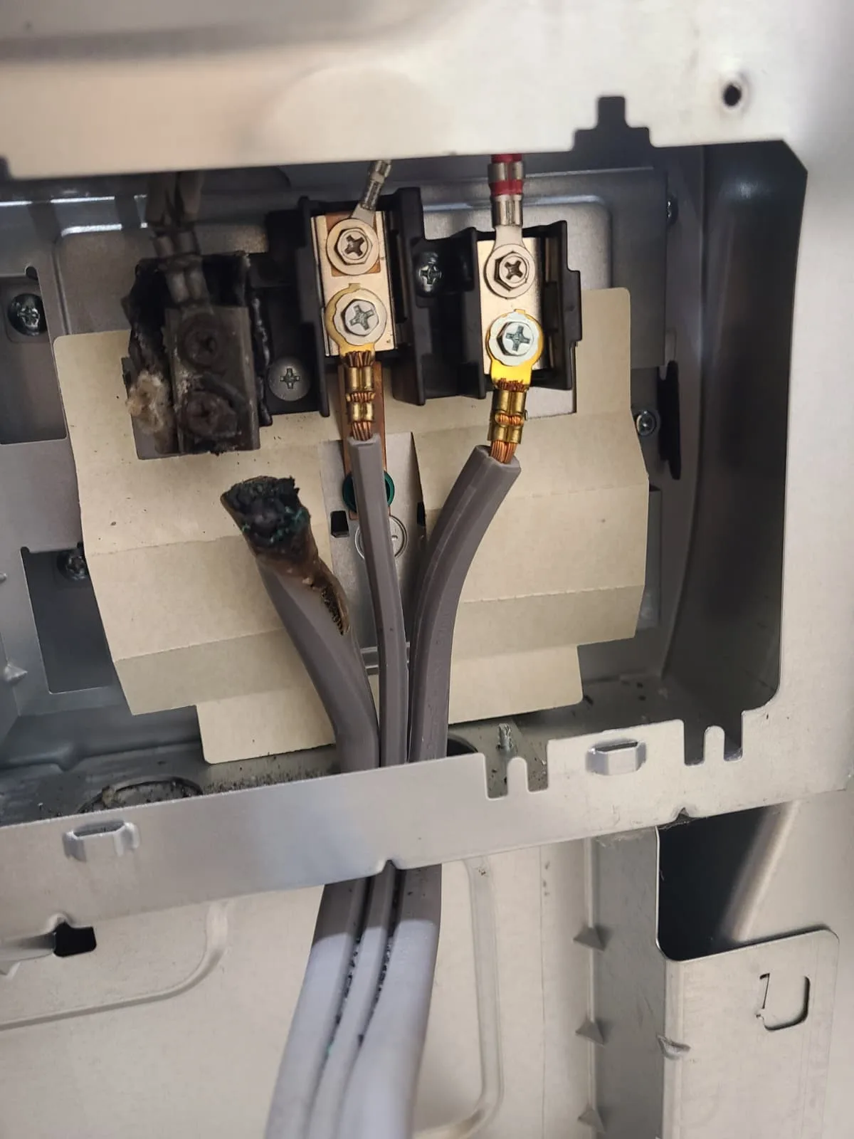 Heat-damaged terminal and disconnected burned power conductor before repair
