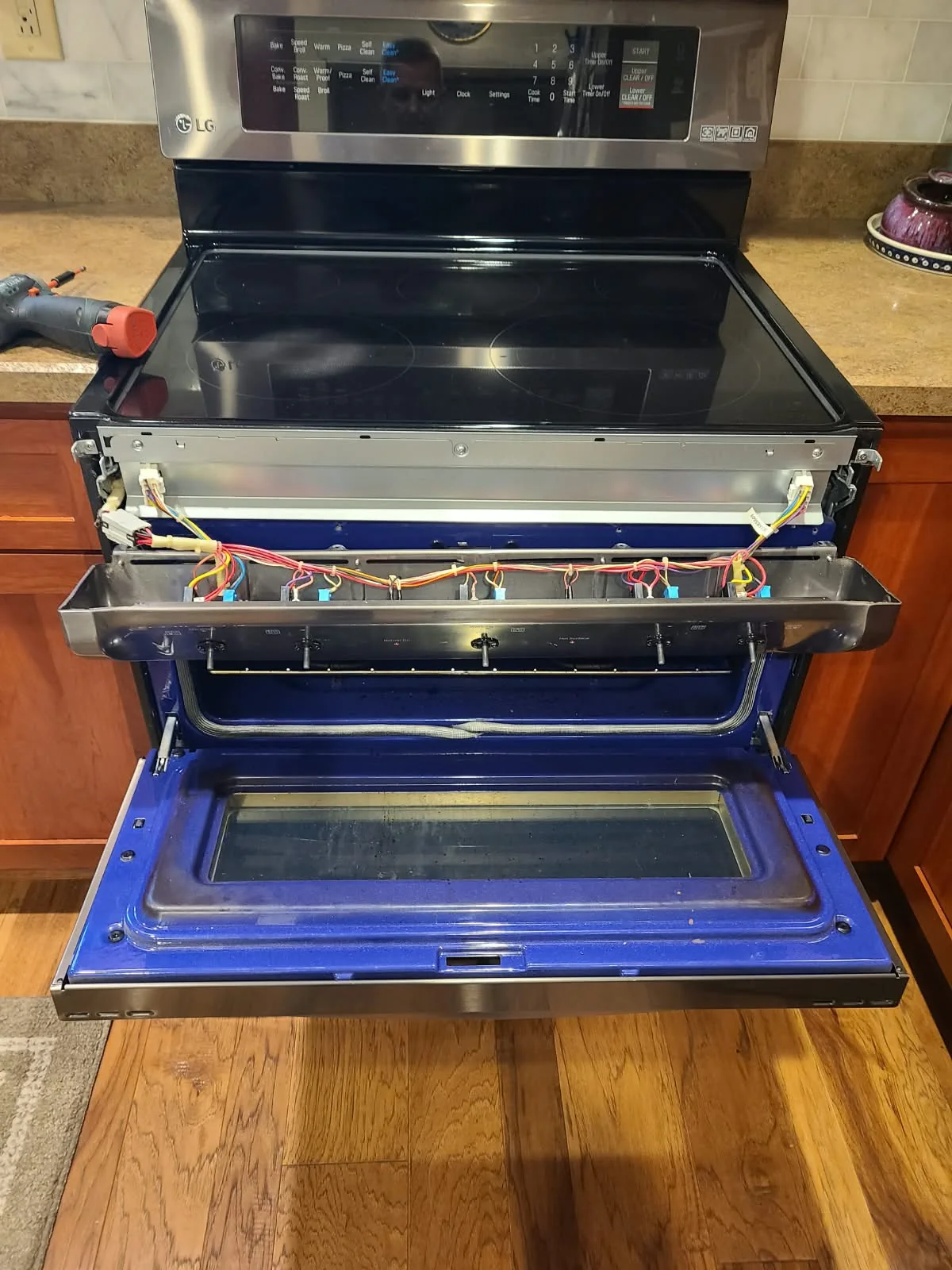 Front control panel opened to access the cooktop burner switches during the LG range repair