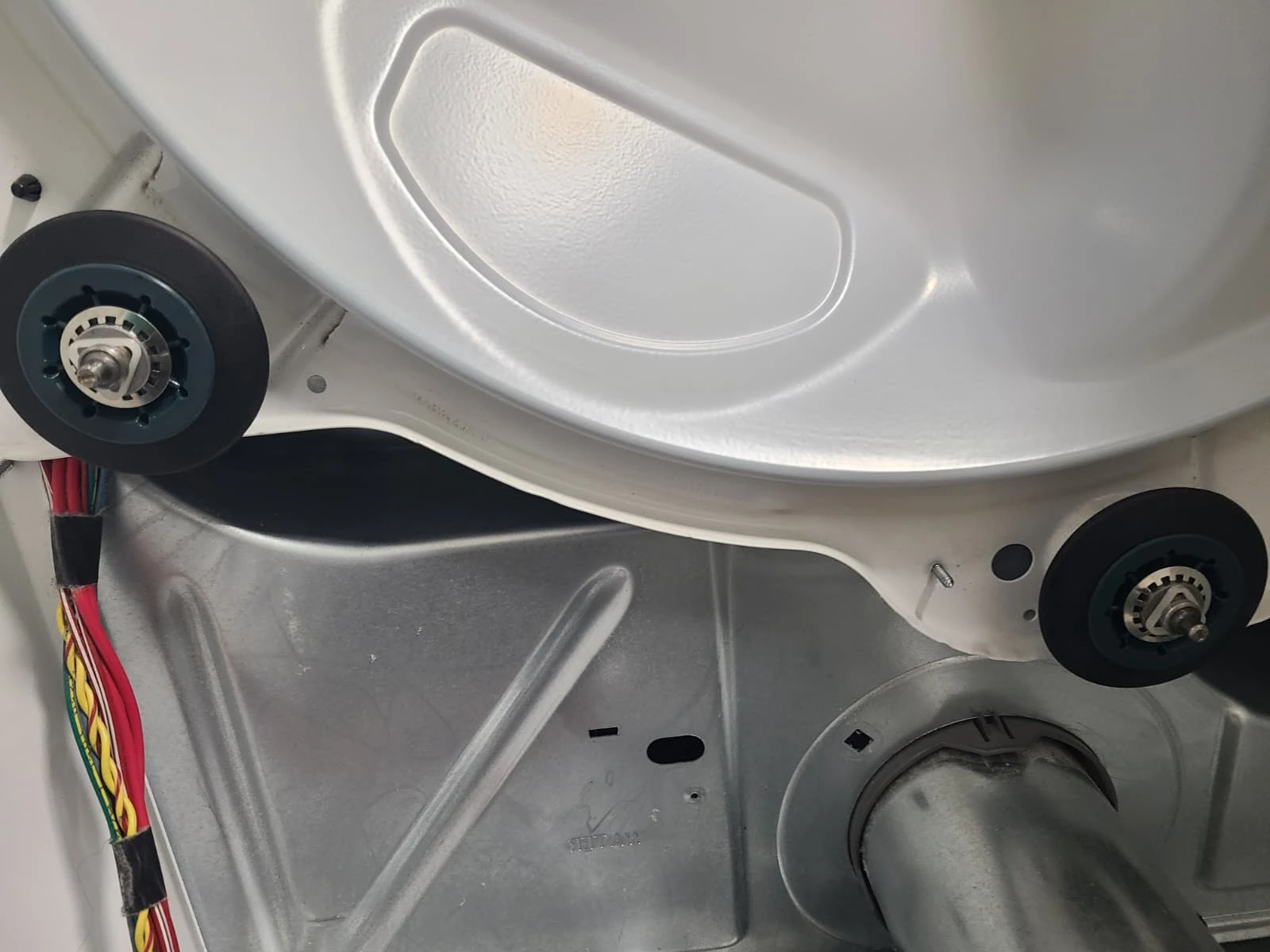Two replacement rear drum support rollers installed on the cleaned bulkhead