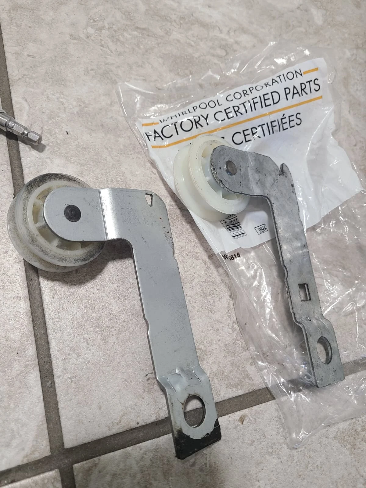 Removed belt idler assembly beside the replacement assembly
