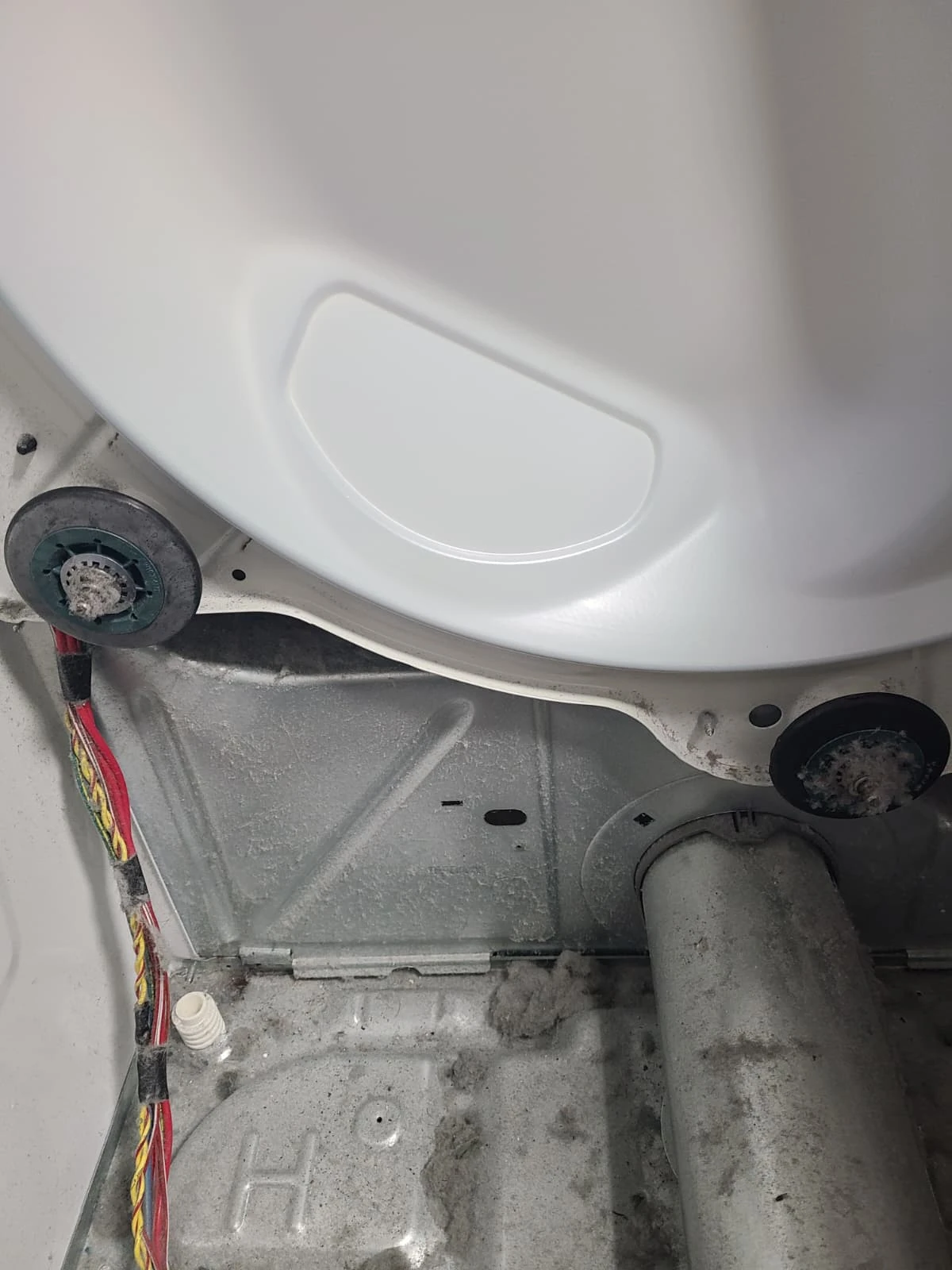 Rear drum support rollers and lint inside the dryer before service