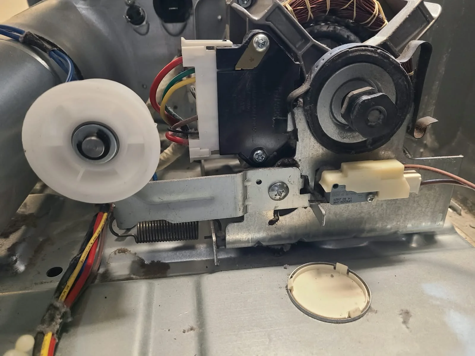 Replacement idler pulley installed beside the motor before belt reassembly