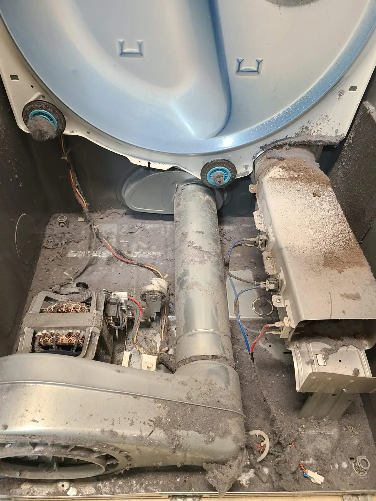 Heavy lint buildup throughout the Samsung dryer cabinet before cleaning
