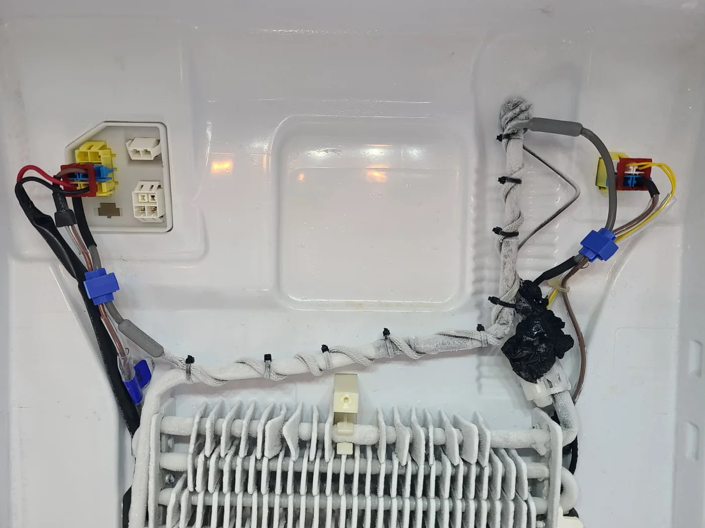 Additional flexible heater installed along the upper tubing during service; frost remains visible at this stage