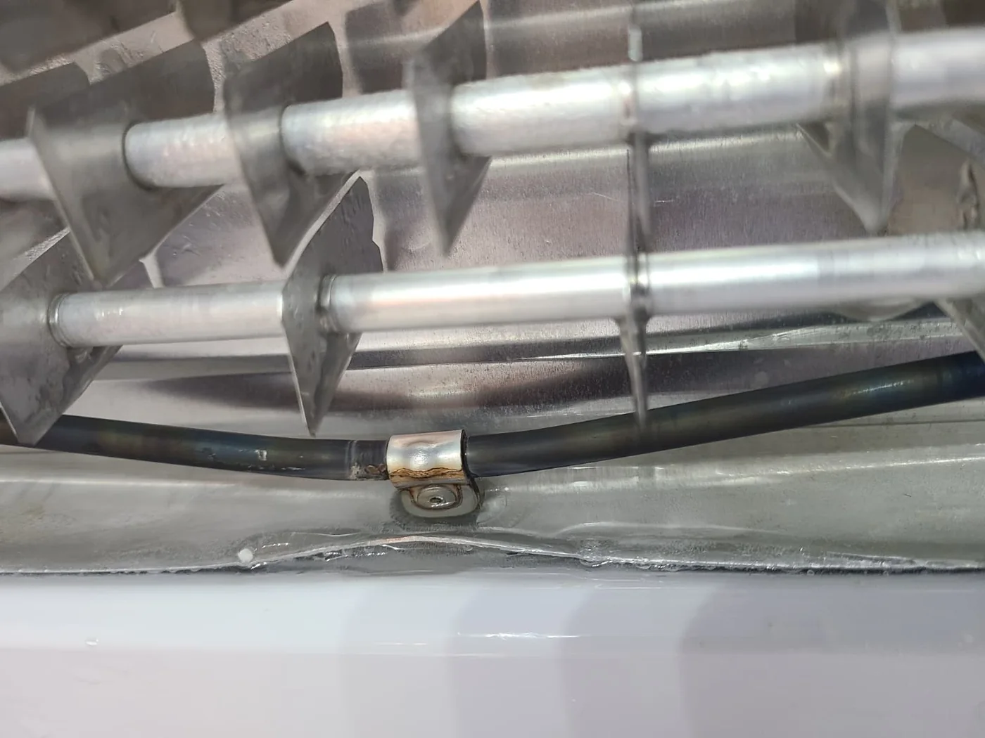 Existing defrost heating element below the evaporator, retained alongside the additional heater
