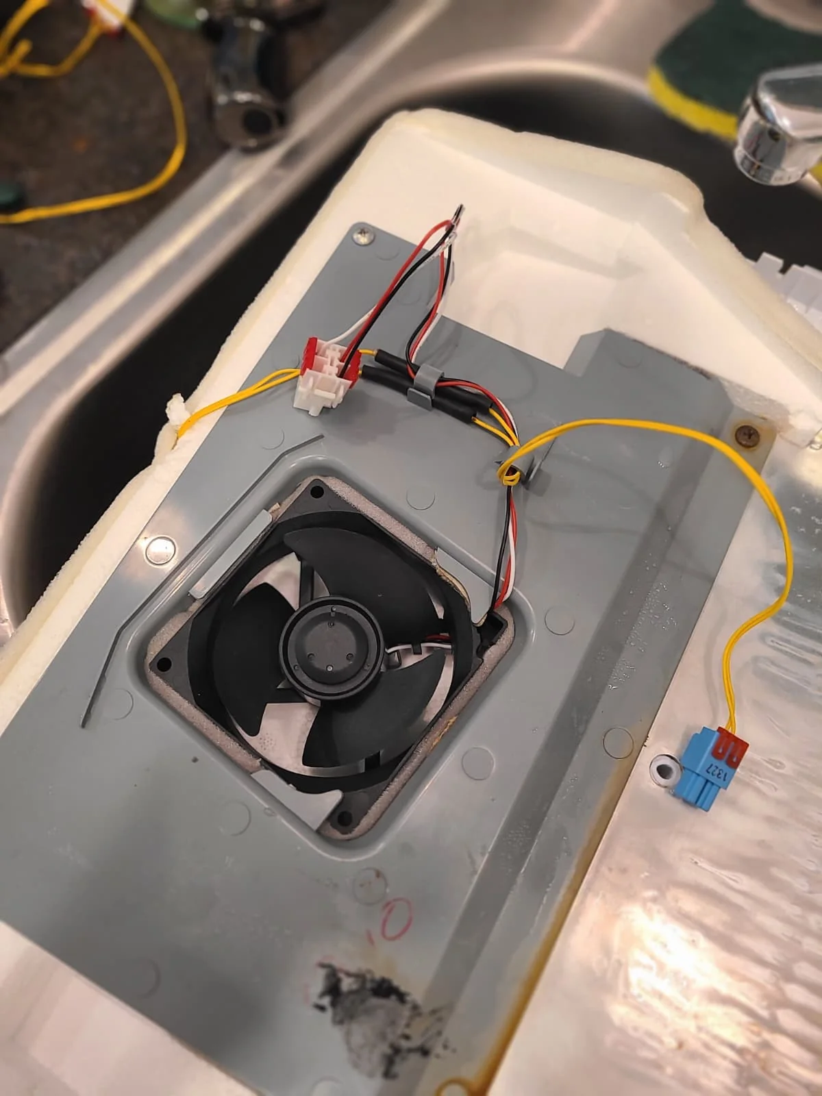 Replacement fresh-food evaporator fan mounted in the cover during the repair