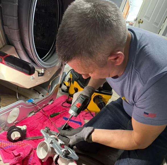 Alex Appliance Repair technician repairing a washing machine with professional tools in an Indiana home